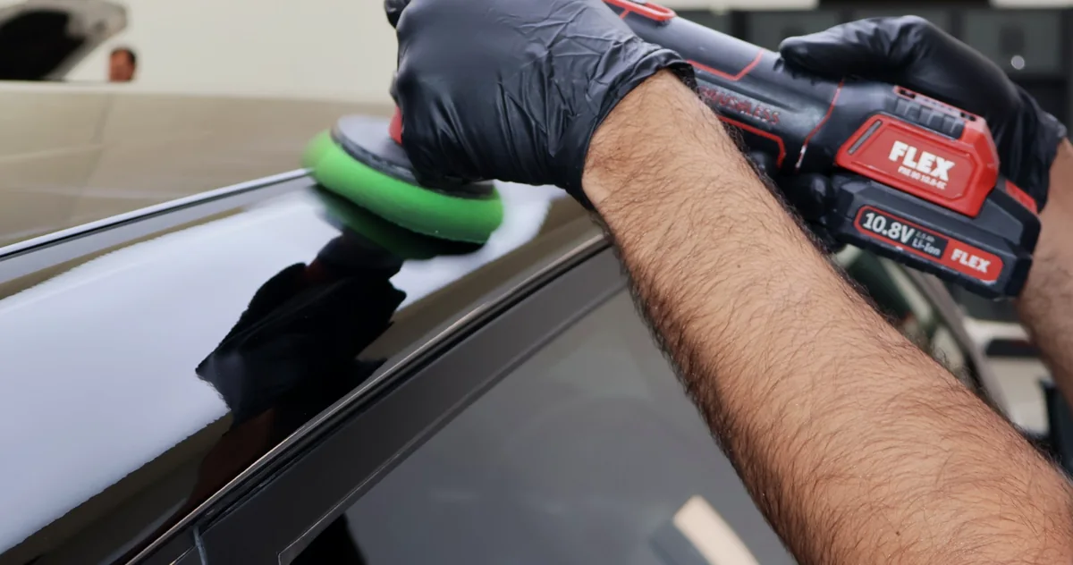 Need for Studio machine polishing the roof edge of a dark car
