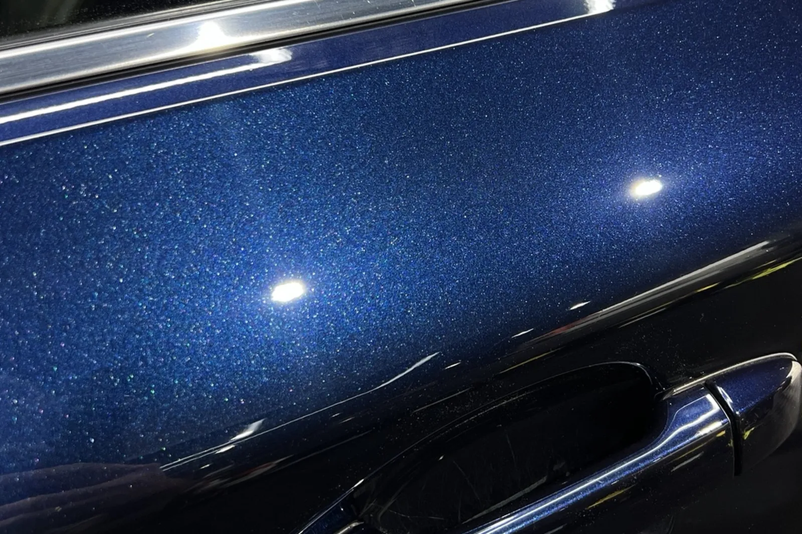 Blue Subaru door after machine polishing — deep, even gloss with no visible swirl marks