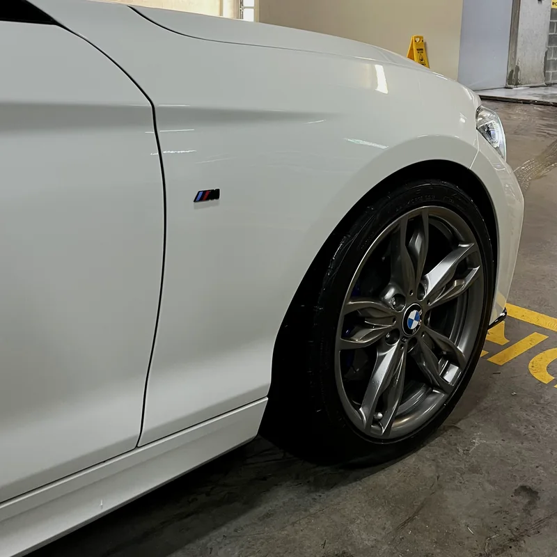 White paintwork, front wing and wheel of a performance hatch after a maintenance wash