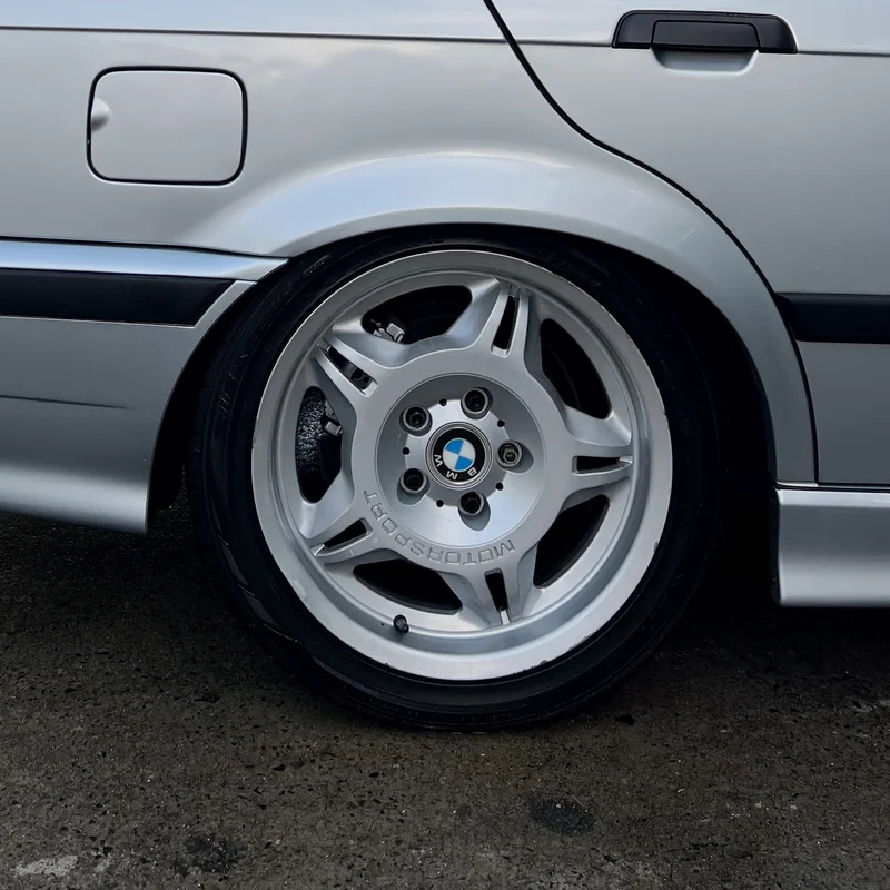Clean wheel, tyre and wheel arch on a silver car after a maintenance wash